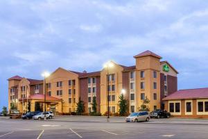 un gran hotel con coches estacionados en un estacionamiento en La Quinta Inn & Suites - New River Gorge National Park en Summersville