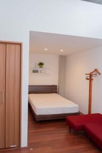 um quarto com uma cama e um sofá vermelho em Kumamoto - Apartment / Vacation STAY 76520 em Kumamoto
