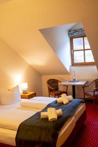 a hotel room with two beds and a table at Landhotel Donaublick in Obernzell