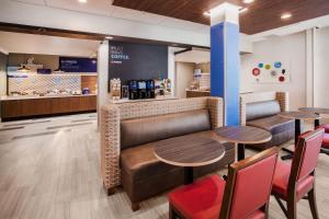 un restaurante con 2 mesas y sillas y una barra en Holiday Inn Express & Suites - Beloit, an IHG Hotel en Beloit