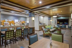um restaurante com mesas e cadeiras e um bar em Holiday Inn Express & Suites Kailua-Kona, an IHG Hotel em Kailua-Kona