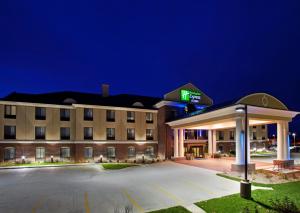 un hotel con un estacionamiento por la noche en Holiday Inn Express Hotel & Suites East Lansing, an IHG Hotel, en East Lansing