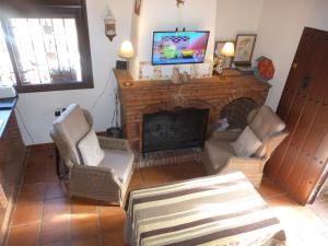 uma sala de estar com lareira e uma televisão por cima em Huerto Los Castaños em Los Marines