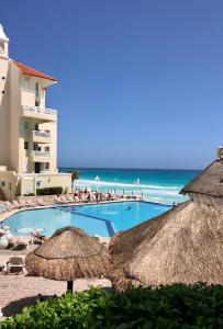 una piscina con sombrillas y la playa en Cancun Beach Aparthotel Brisas, en Cancún