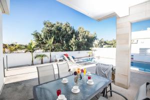 a patio with a table and chairs and a pool at Flouressia Villa 4 in Protaras