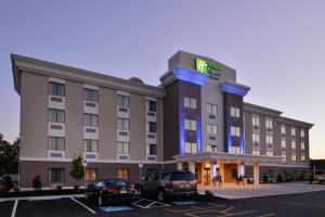 Un hotel con coches aparcados en un estacionamiento. en Holiday Inn Express and Suites West Ocean City by IHG, en Ocean City