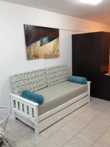 1 cama blanca con almohadas azules en una habitación en LAS MARINAS RENT en Bahía Blanca