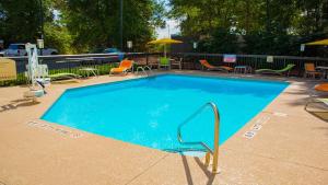 a large blue swimming pool with chairs and umbrellas at Holiday Inn Express Hotel & Suites Kinston by IHG in Kinston