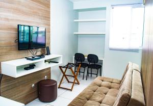 sala de estar con sofá y TV en Kit Net - Vila Verde Sudoeste, en Brasilia