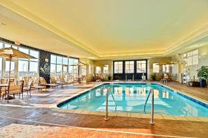 uma piscina no átrio do hotel com cadeiras e mesas em Holiday Inn Express & Suites - Williston, an IHG Hotel em Williston