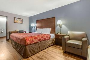 ein Hotelzimmer mit einem Bett und einem Stuhl in der Unterkunft Econo Lodge in Rock Hill