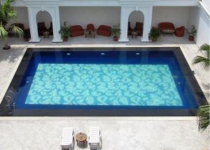a large blue swimming pool with chairs and tables at Ritz Plaza in Amritsar