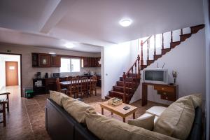 a living room with a couch and a table and a kitchen at Ponta Delgada Guest House 2 in Arrifes