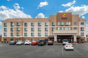 un hotel con coches estacionados en un estacionamiento en Comfort Inn & Suites, en Heath