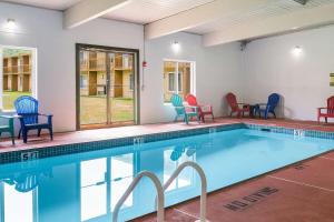 a swimming pool with colorful chairs and a table at Fairmount Inn & Suites - Stroudsburg, Poconos in Delaware Water Gap