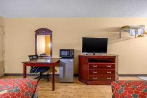 a hotel room with a desk and a television at Econo Lodge in Decatur