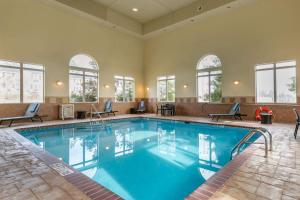 uma grande piscina com água azul num quarto de hotel em Comfort Suites em Batesville