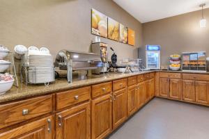 a kitchen with wooden cabinets and a counter top at Comfort Suites Batesville in Batesville