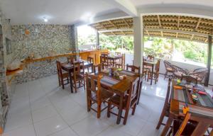 a dining room with wooden tables and chairs at Pousada Barros in Jericoacoara