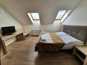 Schlafzimmer mit Oberlichtern und einem Bett im Dachgeschoss in der Unterkunft Hotel Residence Select in Prag
