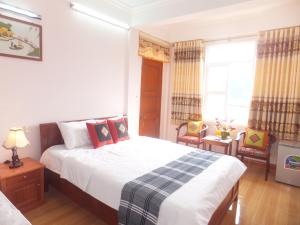 een slaapkamer met een bed en 2 stoelen en een raam bij Tam Cốc Anna Thắm Hotel in Ninh Binh