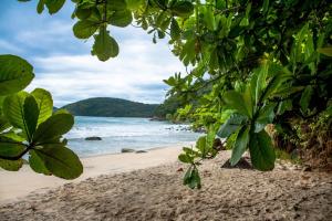 a beach with a view of the ocean at Manacá Suítes Prumirim in Ubatuba