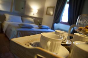 una camera d'albergo con tavolo con tazze e vassoio di cibo di Le Quattro Terre a Corte Franca