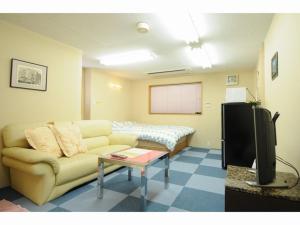 a living room with a couch and a bed at BK Hotel & Weekly in Wakayama