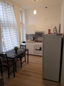a kitchen with a table and a refrigerator at SouvenirAppart Wilenska in Bydgoszcz +56 photos