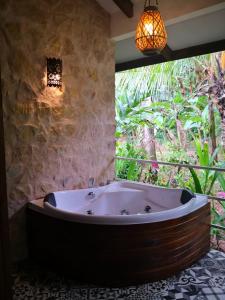 bañera grande en una habitación con ventana en Boutique Hotel y Spa Tangara Azul, en Ojochal