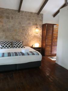 a bedroom with a bed and a stone wall at Boutique Hotel y Spa Tangara Azul in Ojochal