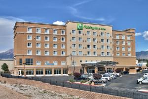 a hotel with cars parked in a parking lot at Holiday Inn & Suites Albuquerque-North I-25 by IHG in Albuquerque