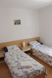 two twin beds in a room with at Apartments Mustač in Drage
