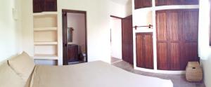 a bedroom with a bed and two wooden doors at Ceiba Studios in Zihuatanejo