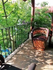 a bench sitting on a porch next to a fence at Ceiba Studios in Zihuatanejo