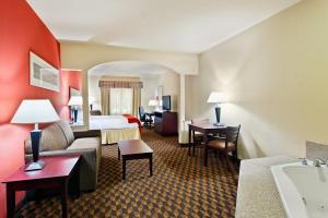 a hotel room with a king bed and a bathroom at Holiday Inn Express & Suites Malvern by IHG in Malvern