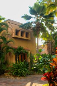 a building with palm trees in front of it at Villas El Rancho Green Resort in Mazatlán