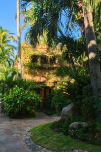a building with palm trees and a courtyard at Villas El Rancho Green Resort in Mazatlán
