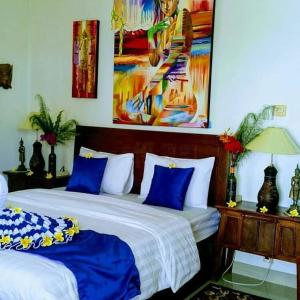 a bedroom with two beds with blue and white sheets at Cantik Villa Tugu Belanda in Lovina