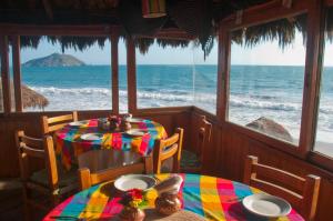 two tables in a restaurant looking out at the ocean at Villas El Rancho Green Resort in Mazatlán