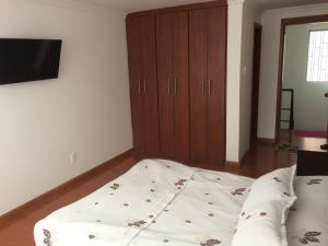 a bedroom with a bed and a tv on a wall at Casa Vacacional La Estación Paipa in Paipa