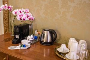 una mesa con cafetera y una cafetera y flores en BQ House Trevi Luxury Rooms, en Roma