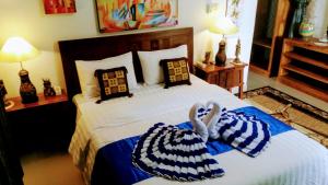 a bedroom with a bed with two towels on it at Cantik Villa Tugu Belanda in Lovina
