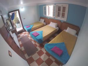 a small room with two beds and two chairs at Dahab Hostel in Cairo