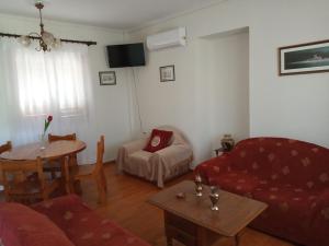 a living room with a red couch and a table at Manousi 1- Ground floor in Mystras