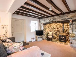 a living room with a stone wall with a fireplace at Y Bwthyn in Criccieth