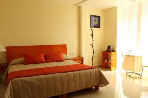 a bedroom with a bed with orange pillows at Hotel Señorial Tlaxcala in Tlaxcala de Xicohténcatl