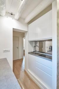 Una cocina con gabinetes blancos y encimera. en Classy Venice, en Venecia