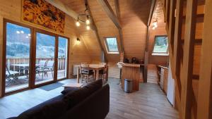 - un salon dans une cabane en rondins avec une table et des chaises dans l'établissement Le Frenola, à Saint-Pierre-dʼEntremont