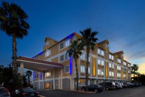Holiday Inn Express & Suites San Antonio - Downtown Market Area, an IHG Hotel في سان انطونيو: فندق فيه نخل امام مبنى